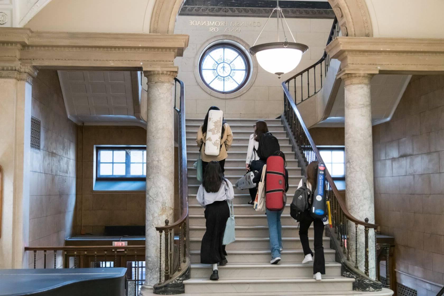 A group of students make their way up a staircase on their way to class at the University of Rochester, Eastman School of Music.